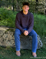 Nick in sweater sitting on rock