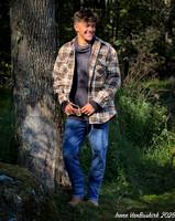 Nick in shirt standing against tree