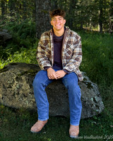 Nick in shirt sitting on rock