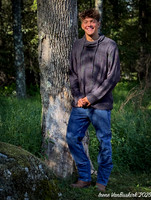 Nick w sweater standing against tree