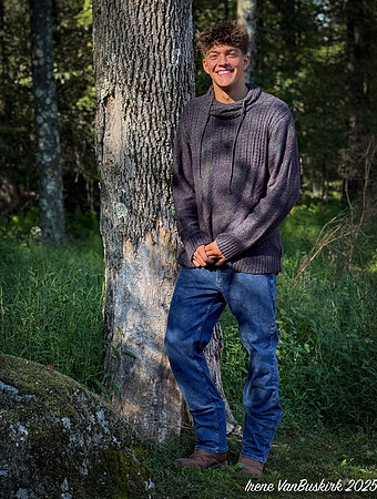 Nick w sweater standing against tree